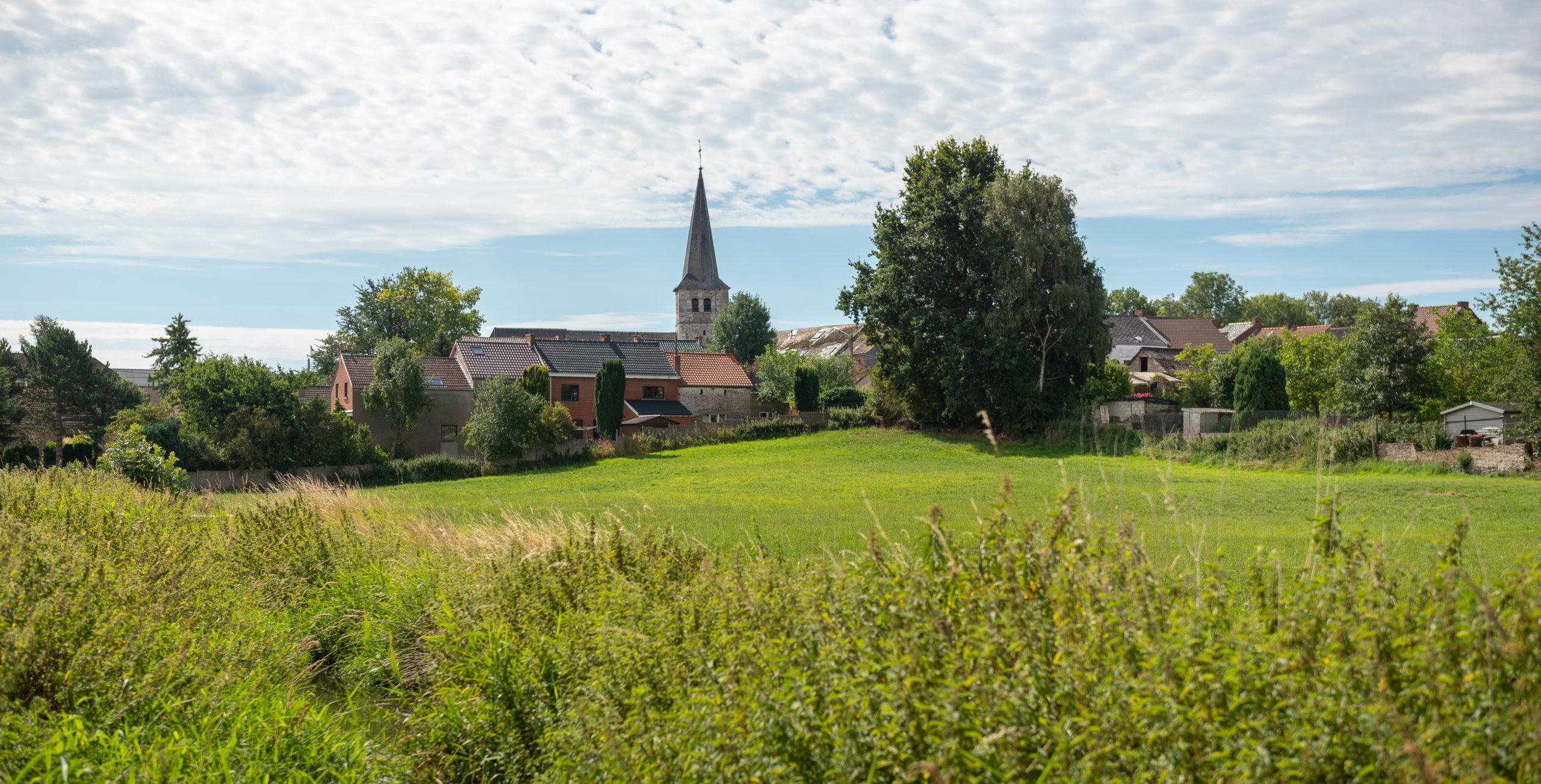 L'église de St-Amand avec des champs en avant plan